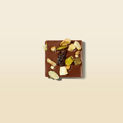 Milk and dark chocolate square topped with nuts, seeds, and dried fruit pieces