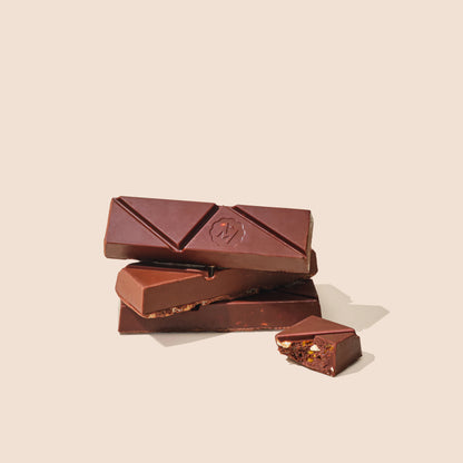 Dark chocolate snack bar with nut filling, shown with broken pieces.