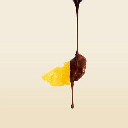 Chocolate-dipped pineapple slice with a dark chocolate drip
